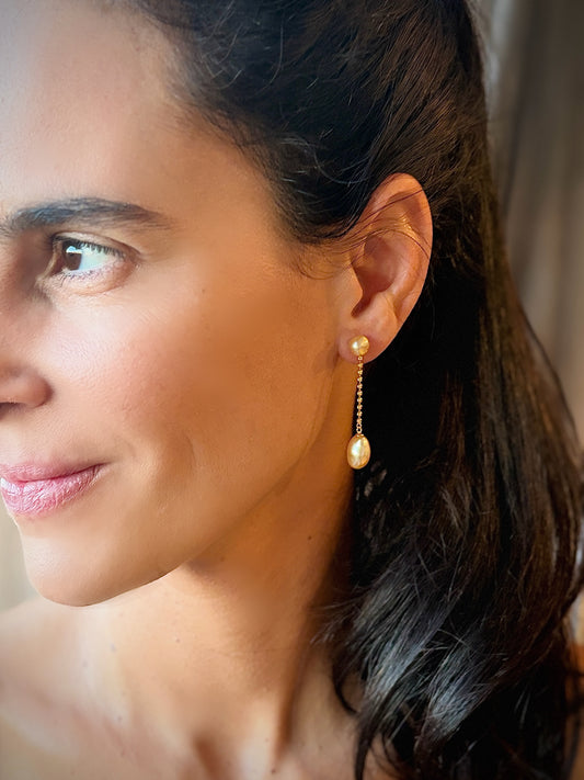 Close-up of woman wearing south sea golden pearl earrings, featuring Keshi pearls and 18K solid gold