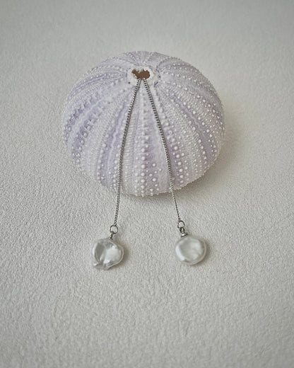 Close-up of silver keshi pearl earrings on a sponge