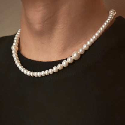 Audrey Hepburn style white freshwater pearl necklace worn by a person