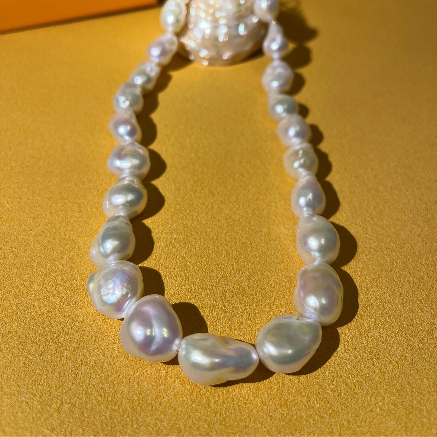Baroque pearl necklace showcasing unique stone-shaped baroque pearls on a vibrant background.