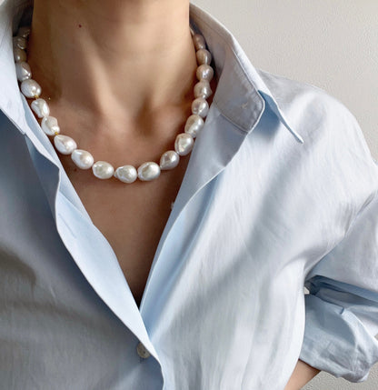 BOLD baroque pearl necklace showcasing unique baroque pearls worn with a light blue shirt.