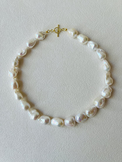 Baroque pearl necklace featuring unique baroque pearls and 24K gold vermeil detailing on a light background.
