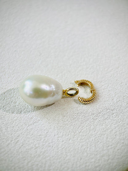 Baroque pearl pendant necklace featuring a distinctive irregular pearl and gold vermeil clasp on a textured background.