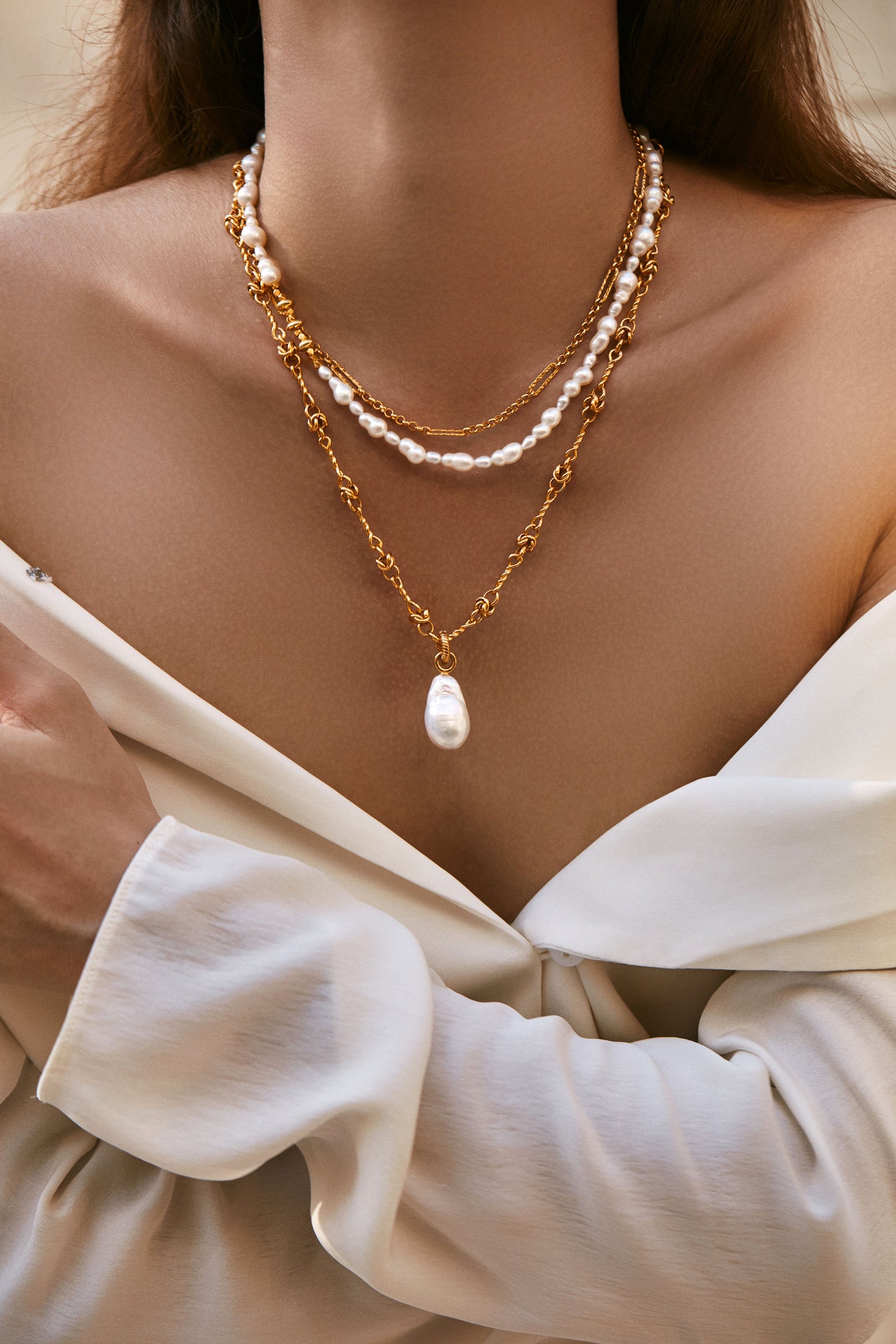 Baroque pearl pendant necklace worn by a model, featuring a bold 18k gold vermeil chain with layered pearls.