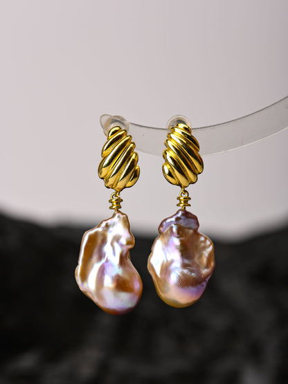 Gold-rimmed baroque pearl earrings on a white background