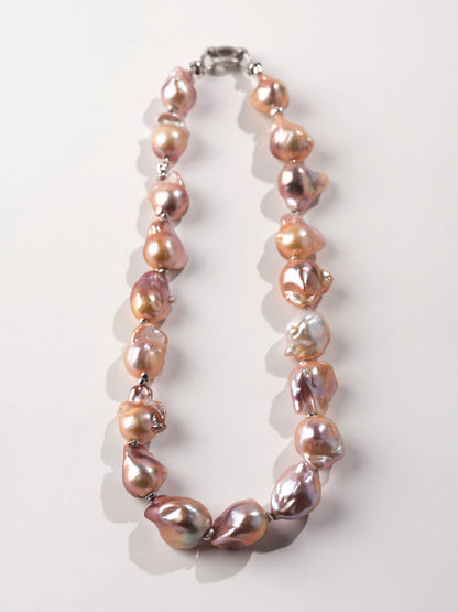Necklace with pink and brown baroque pearls on a white background