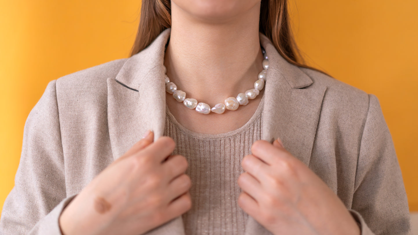 Baroque Pearl Necklace - BOLD worn by model with chic style against a yellow background, showcasing its elegant design.