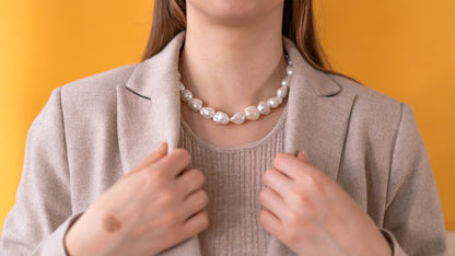 Baroque Pearl Necklace - BOLD worn by model with chic style against a yellow background, showcasing its elegant design.