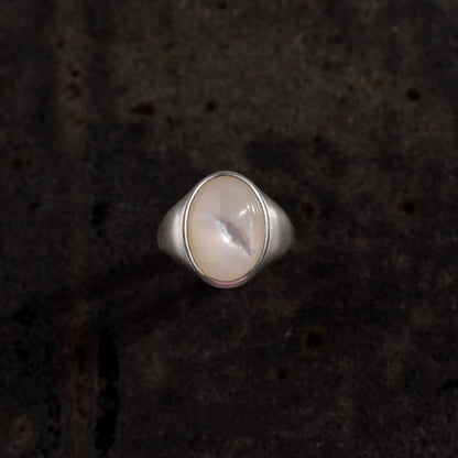 Silver ring with a round stone on a dark textured background