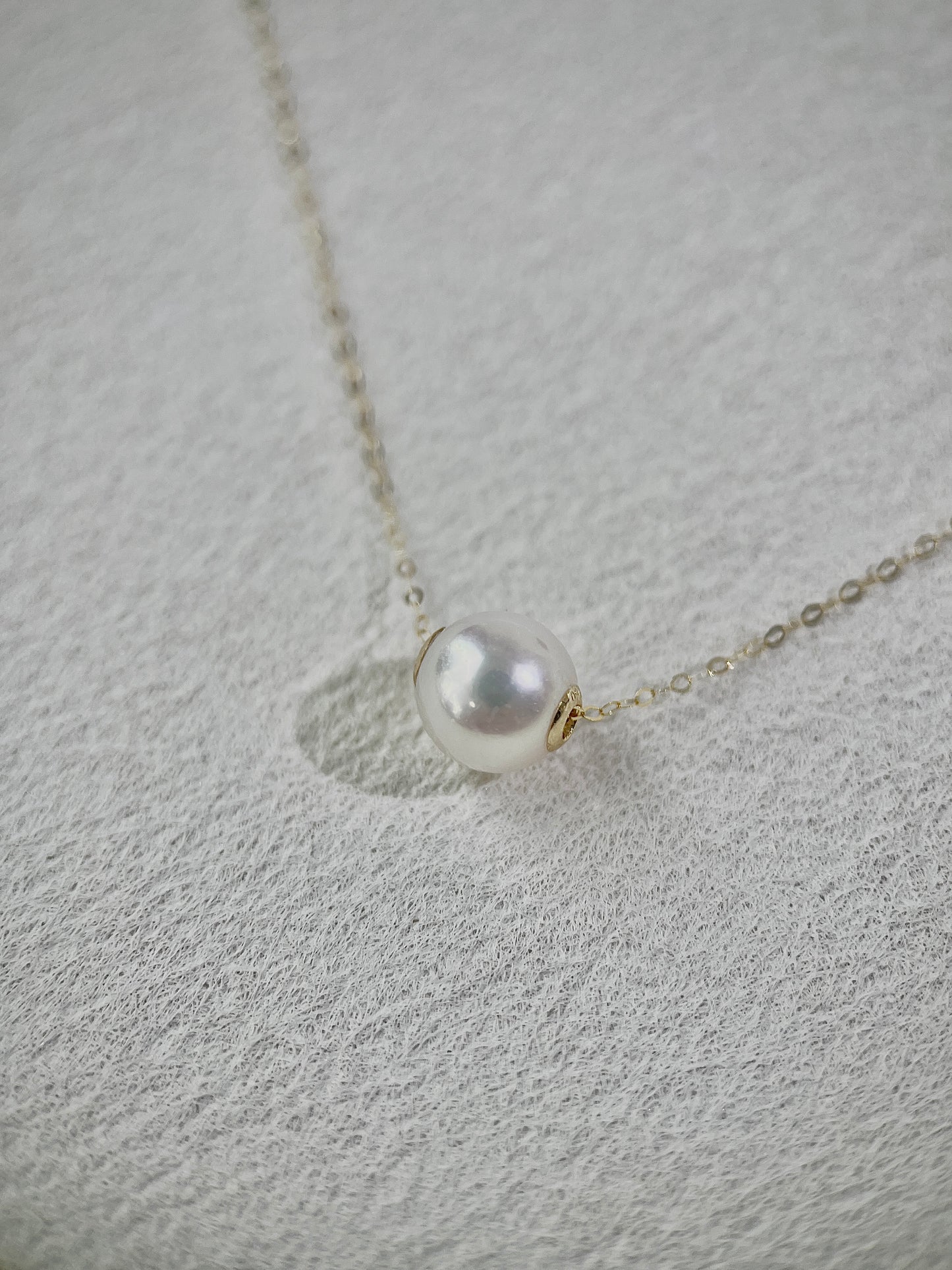 Pearl necklace on a textured gray surface