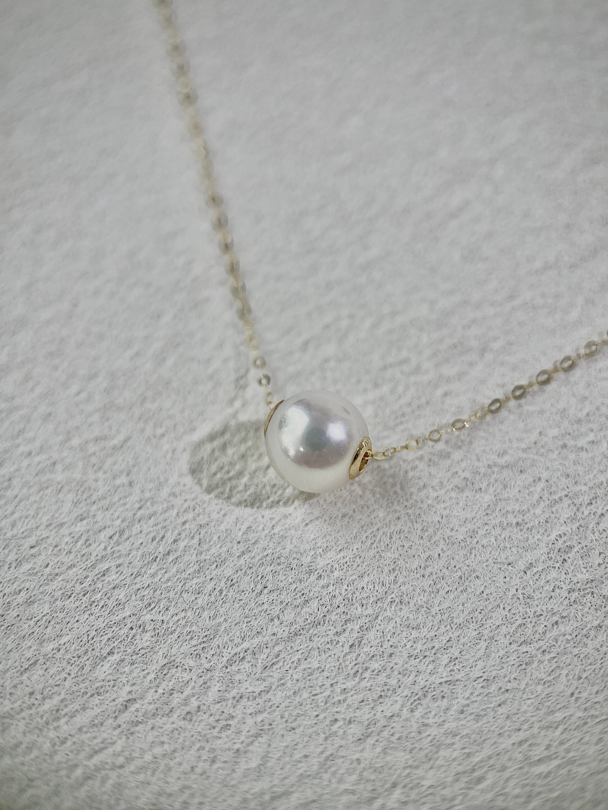 Pearl necklace on a textured gray surface