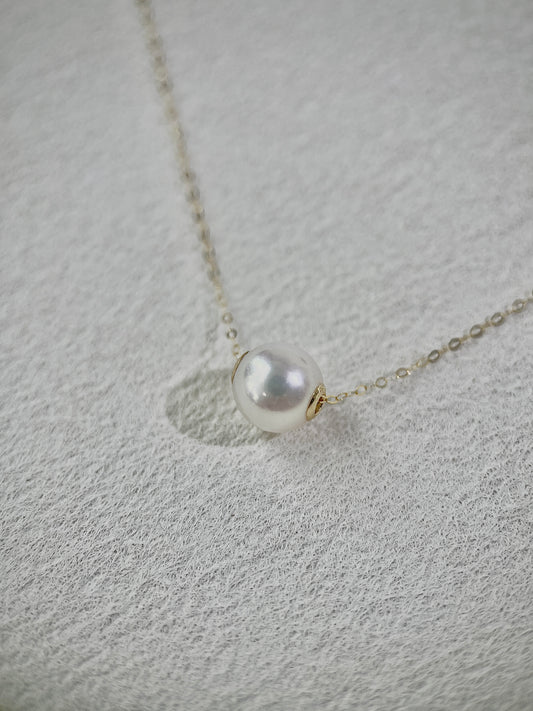 Pearl necklace on a textured gray surface