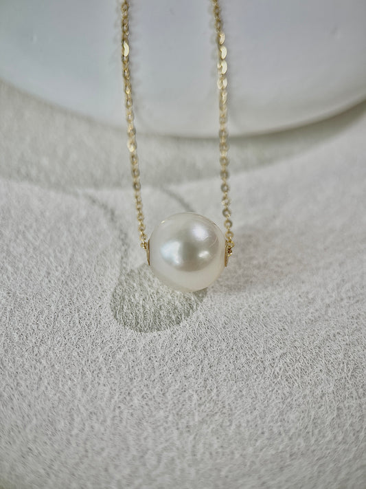 Pearl pendant necklace on a textured white surface