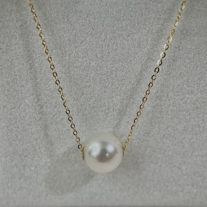 Pearl pendant necklace on a soft gray background