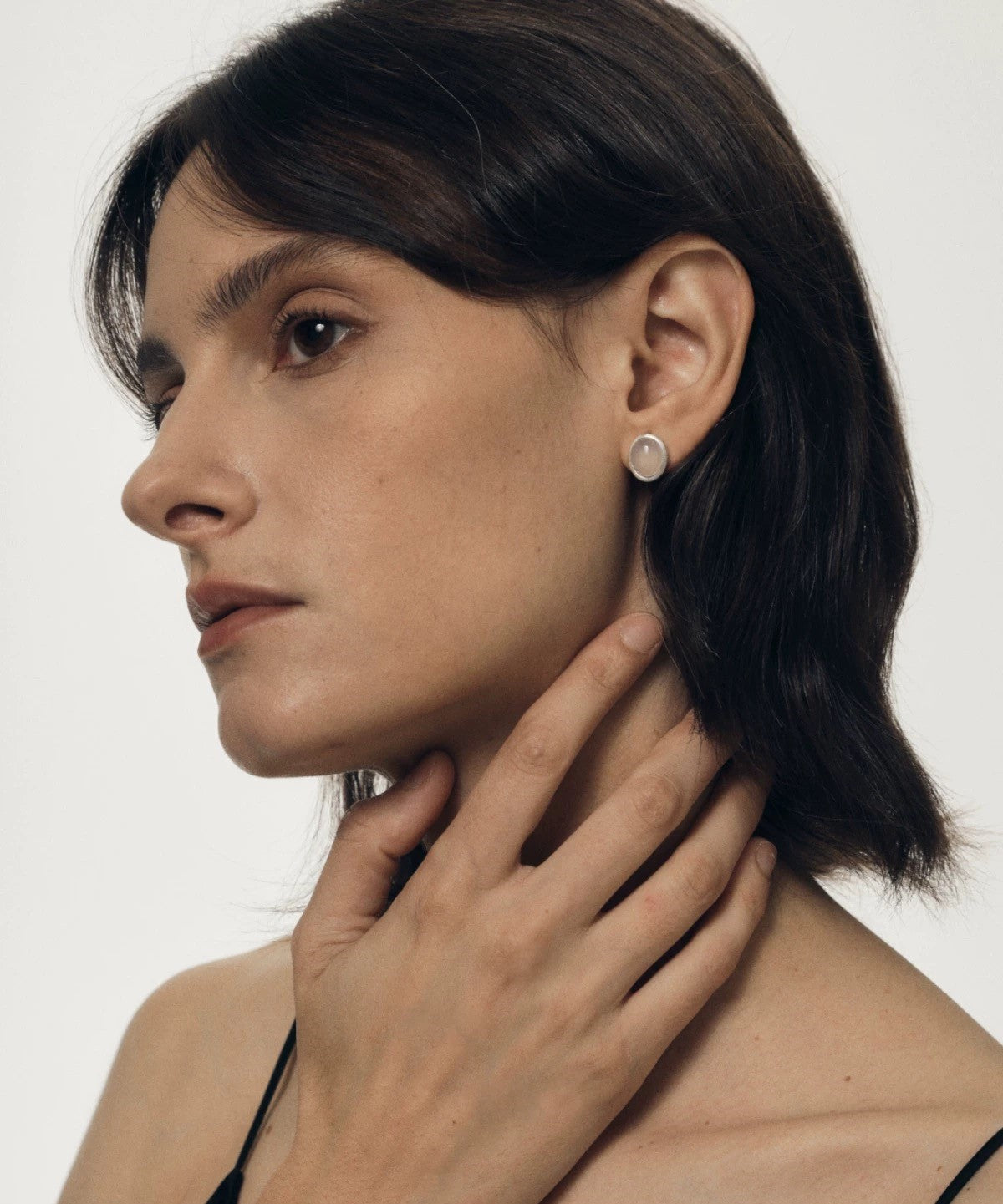 Woman wearing earrings with a neutral background