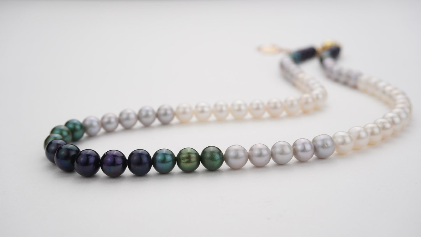 Strand necklaces with gradient pearls on a light gray background