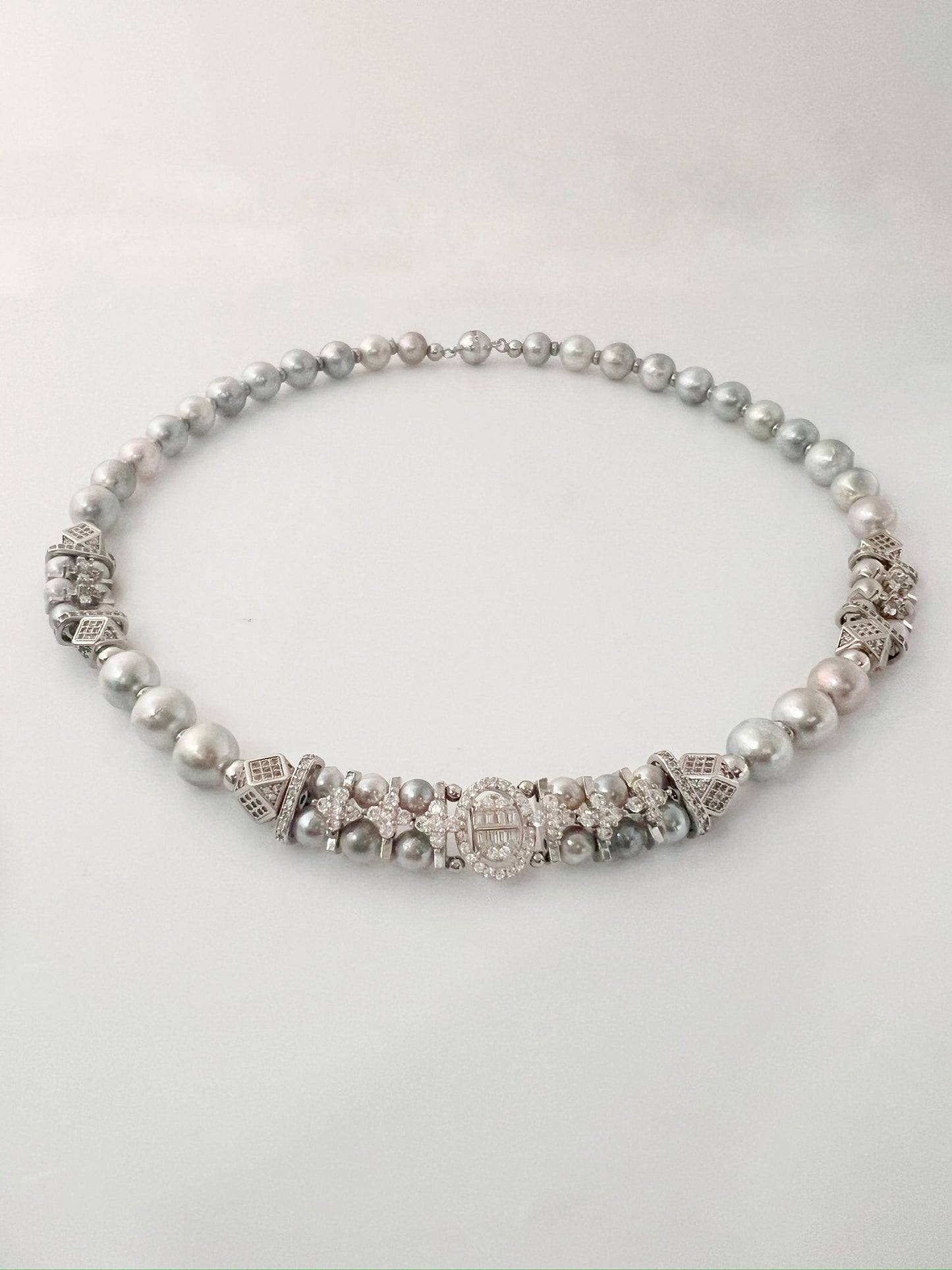 Pearl and silver beaded necklace on a white background