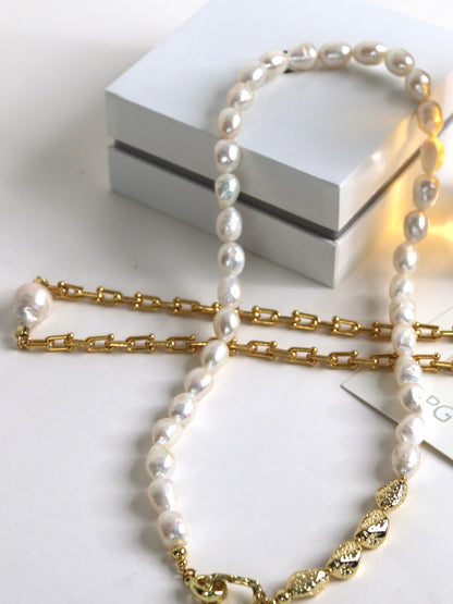 Pearl necklace for men with gold chain on a white surface