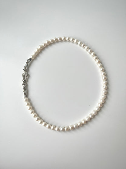White Freshwater pearl necklace on a light gray background