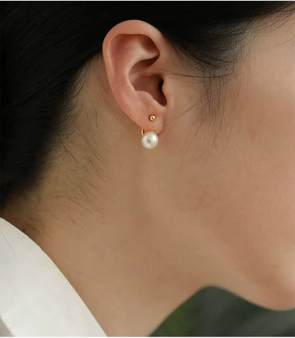 Pearl earring worn by a person with a neutral background