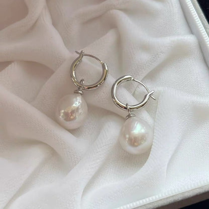 Pearl earrings on a soft white fabric background