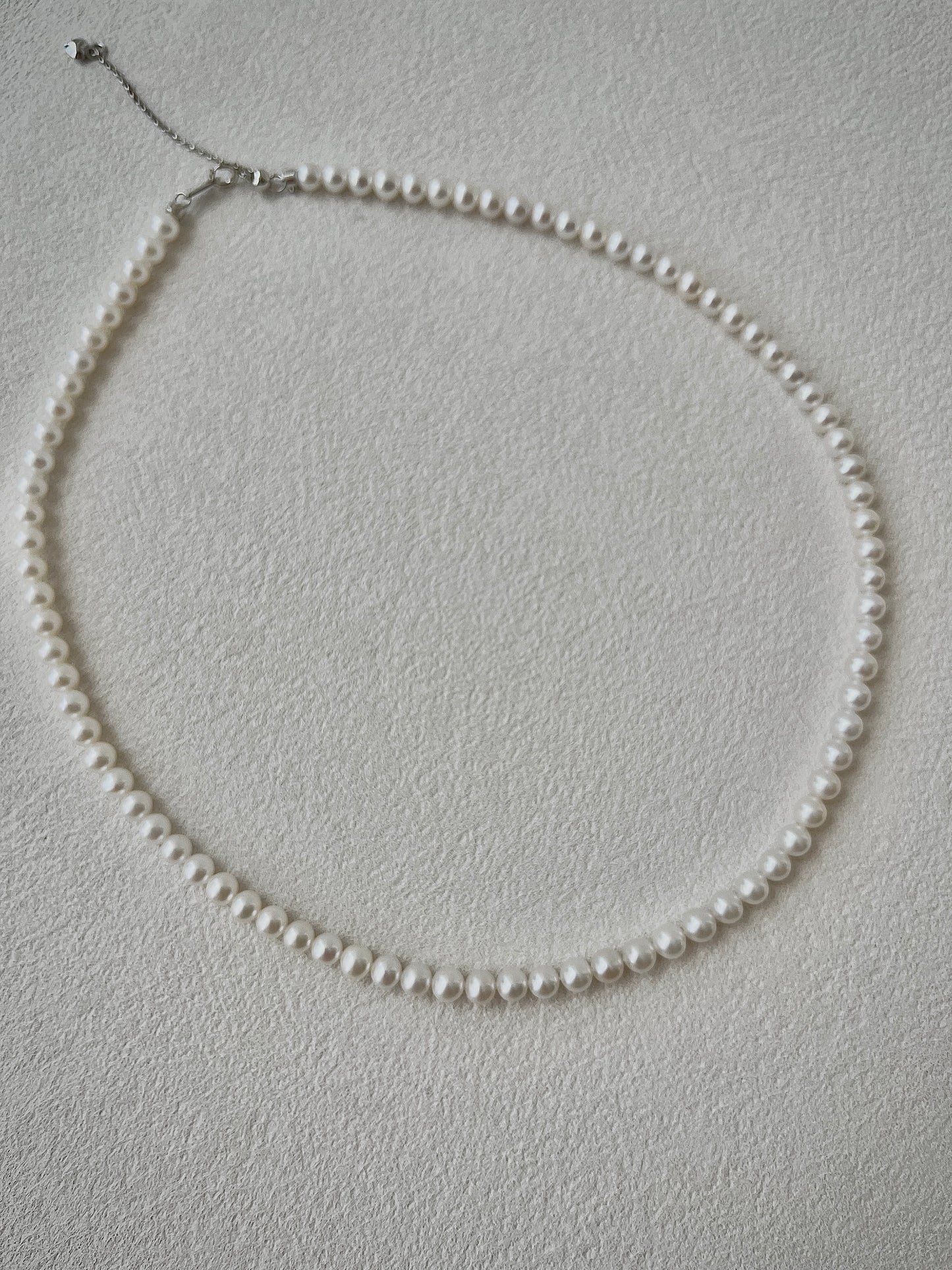Pearl necklace on a light gray background