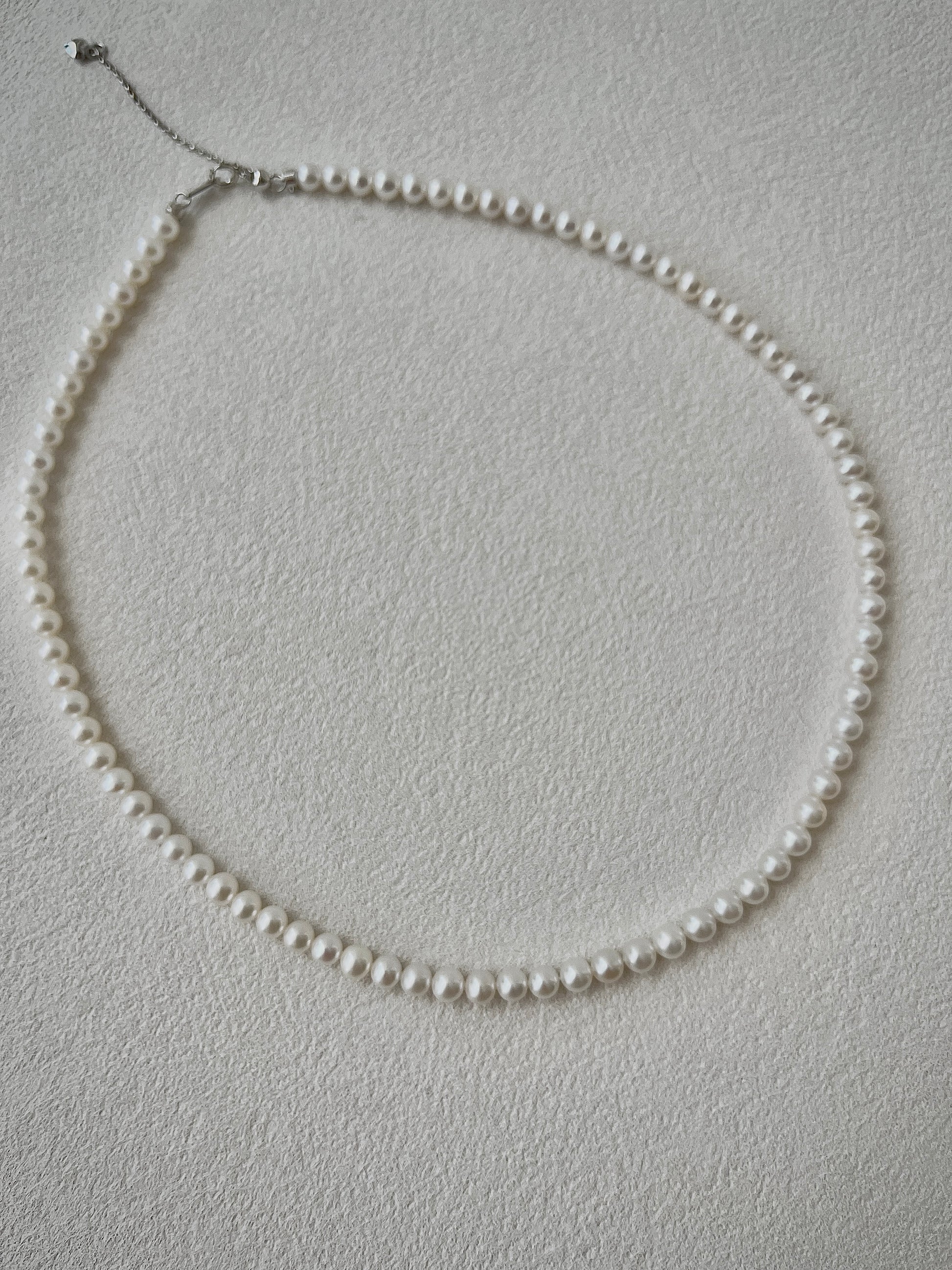 Pearl necklace on a light gray background