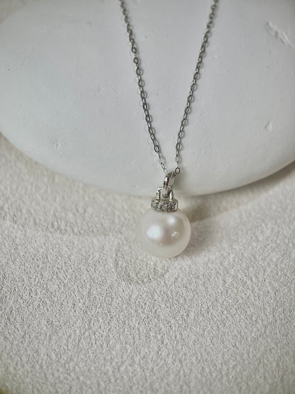 Pearl Pendant necklace with silver chain on a textured white surface