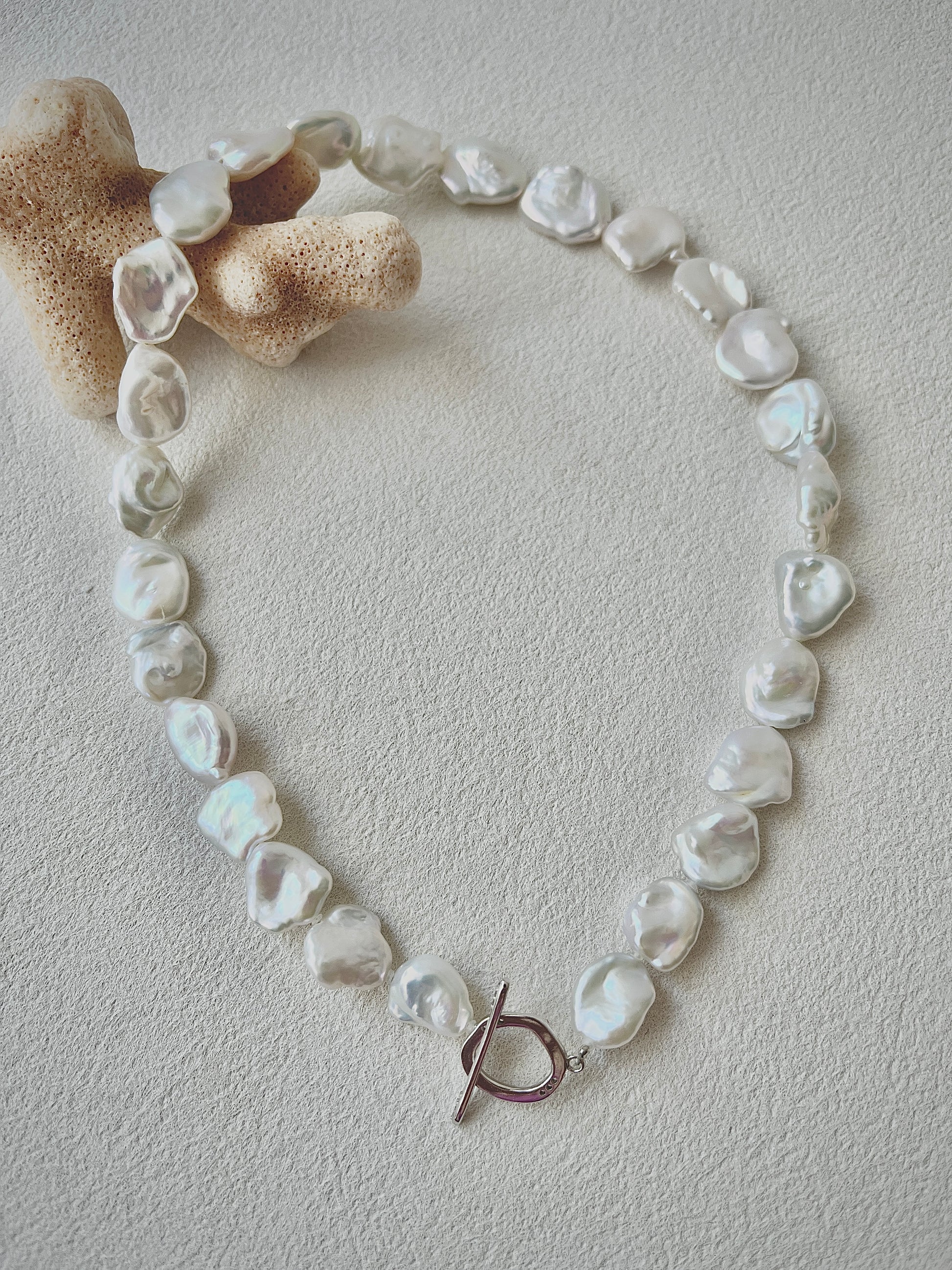Pearl necklace with a toggle clasp on a light background