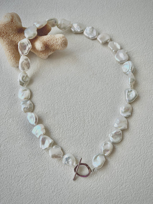 Pearl necklace with a toggle clasp on a light background
