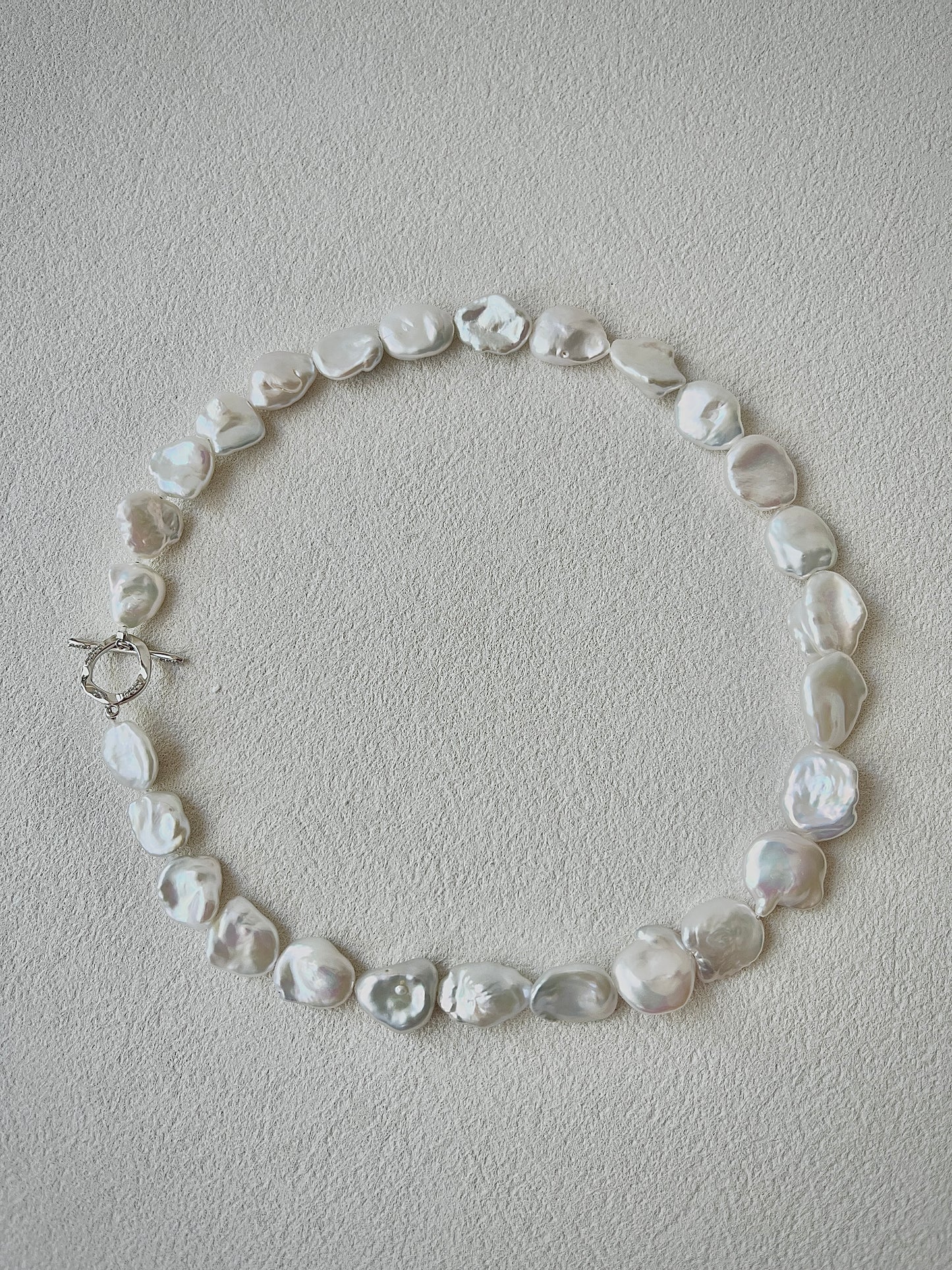 Pearl necklace on a light gray background