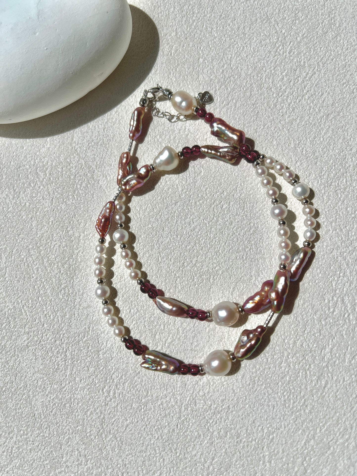 Multistrand pearl and beaded necklace on a light surface