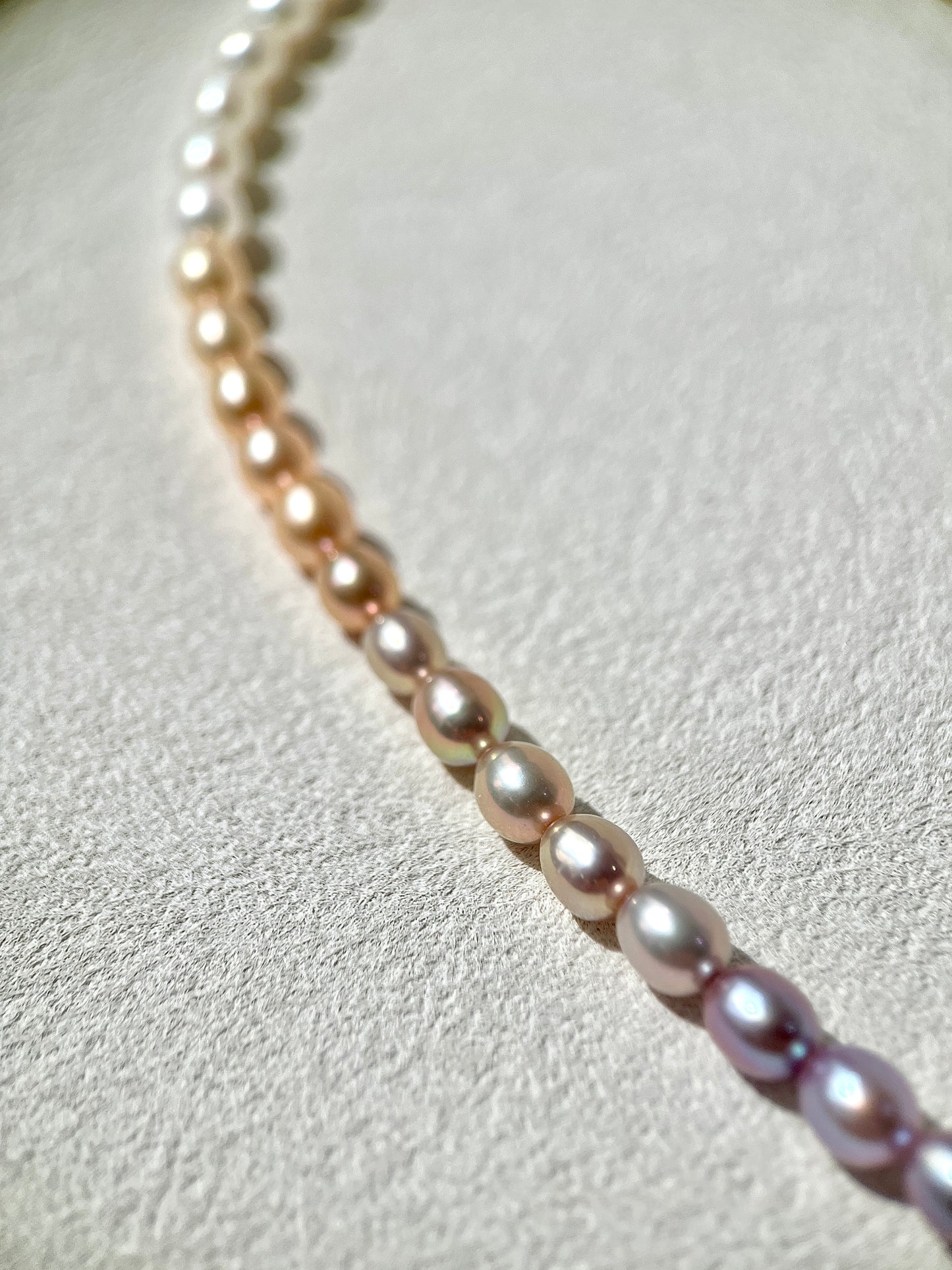Close-up of a pearl necklace on a light gray background
