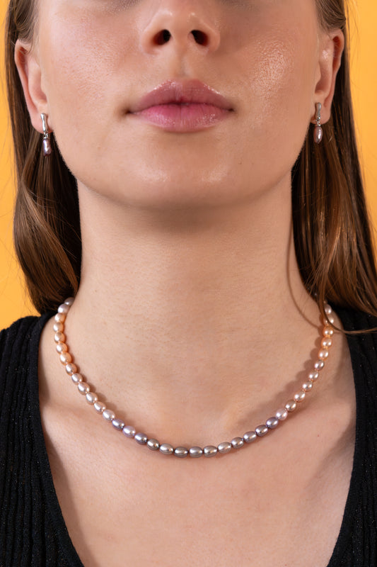 Woman wearing a rainbow pearl necklace with a blurred background