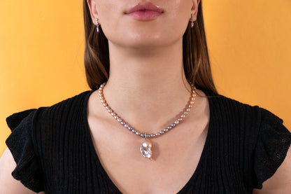 Woman wearing a pearl necklace against an orange background