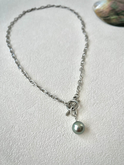 Necklace with a single pearl pendant on a light gray background