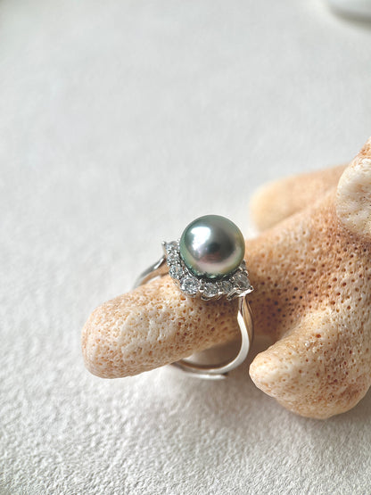 Tahitian Pearl ring with silver band on a textured beige surface