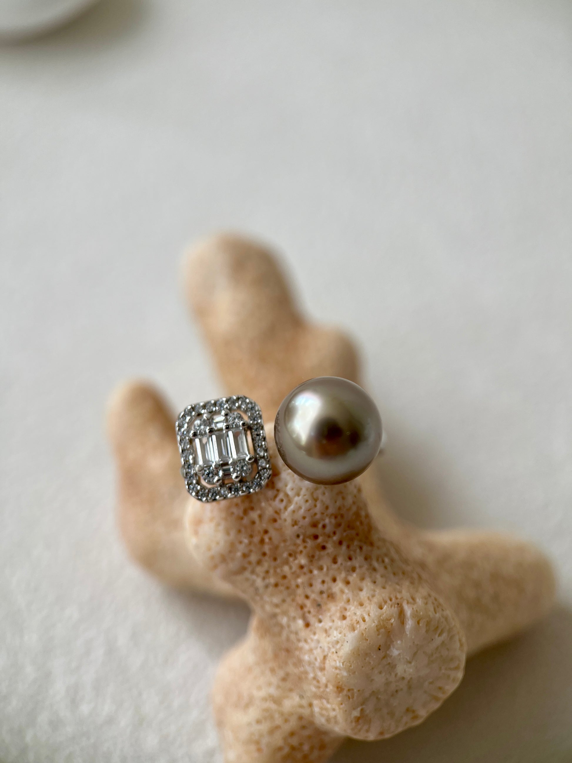 Ring with a pearl and a diamond, on a piece of coral.