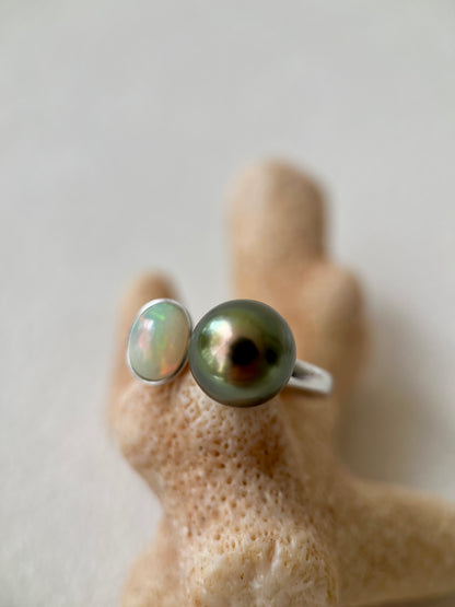Tahitian Black pearl ring with Opal on a hand with a neutral background