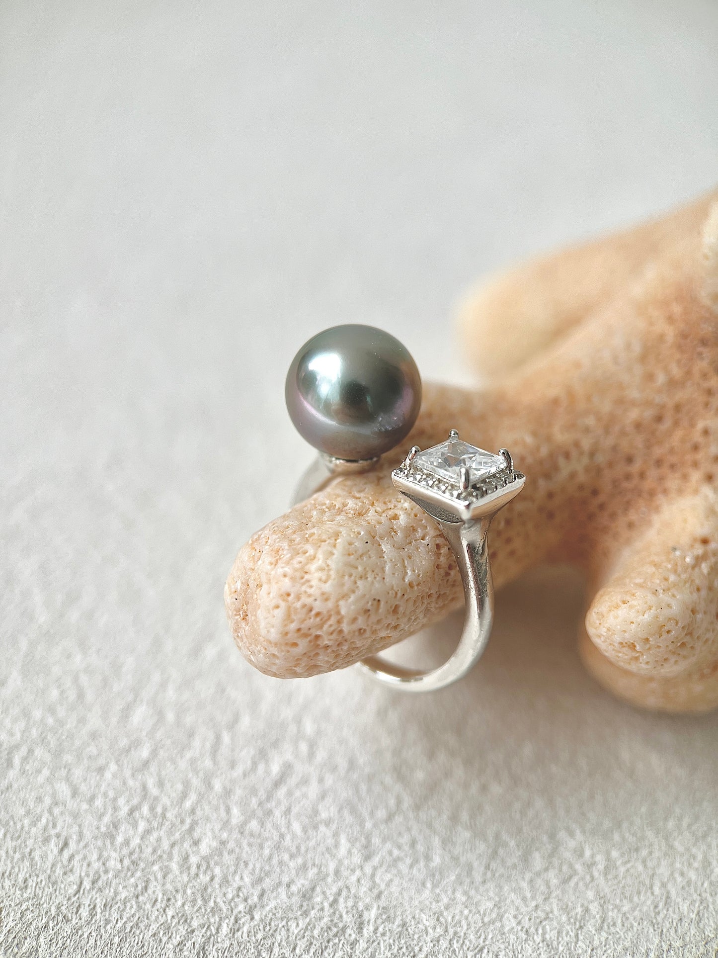 Silver ring with a large Tahitian pearl and smaller diamond on a starfish
