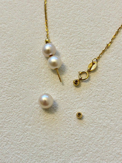Gold necklace with pearls on a light gray background