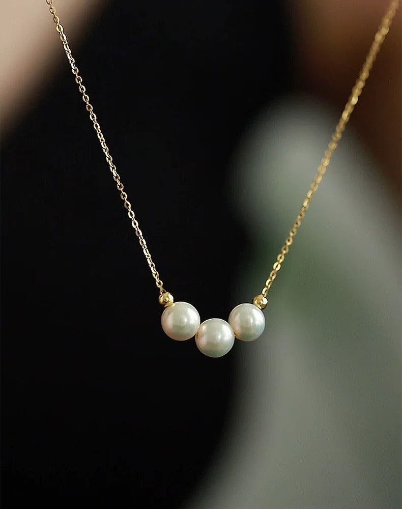 Pearl necklace with gold chain on a blurred background