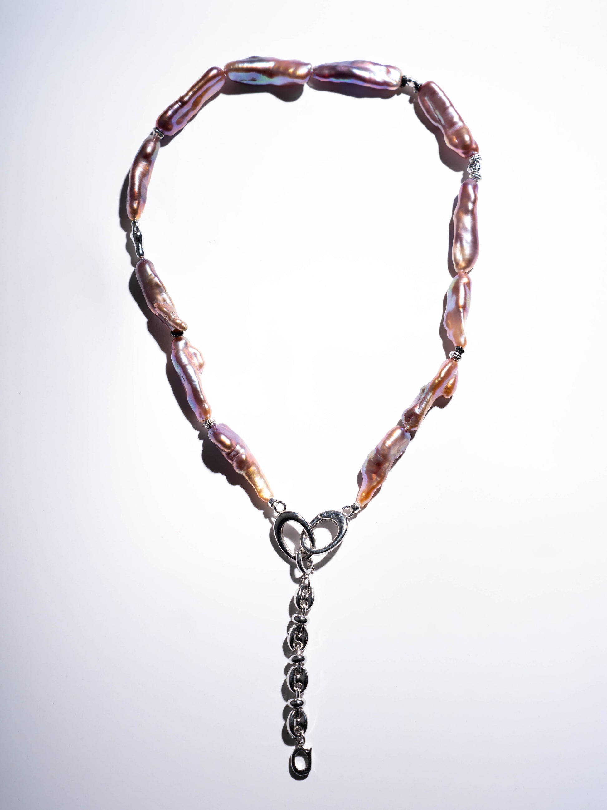 Pearl Necklace with pink and brown beads and a silver clasp on a light gray background