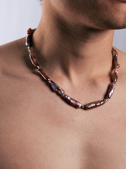 Pearl Necklace with brown beads on a person's neck against a neutral background