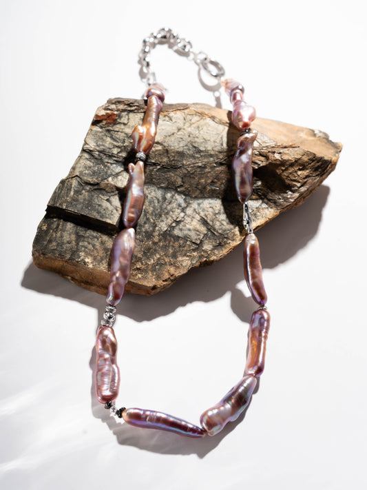 pearl Necklace with pink beads on a rock