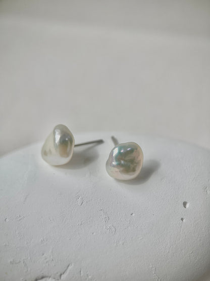 Pearl earrings on a light gray surface