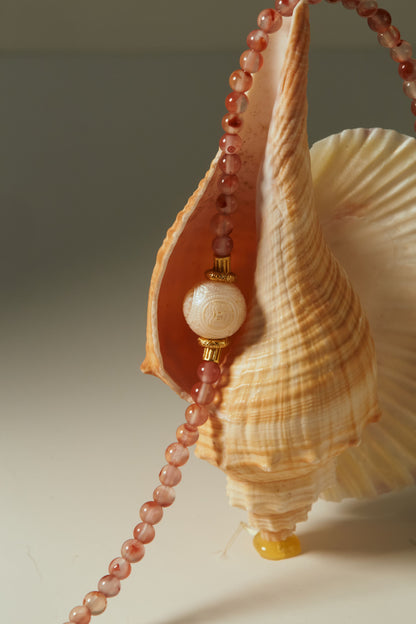 Seashell with a decorative white freshwater pearl and red carnelian chain necklace