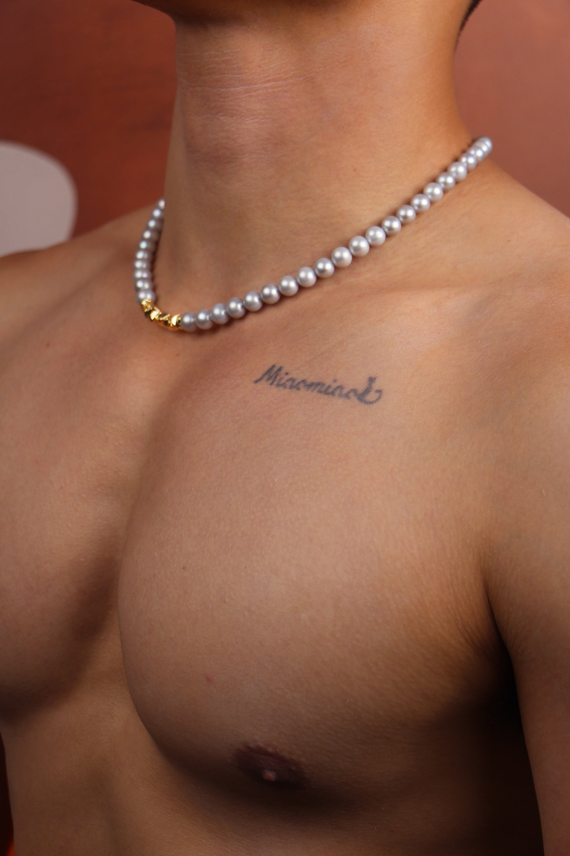 Men wearing silver pearls on a gold necklace