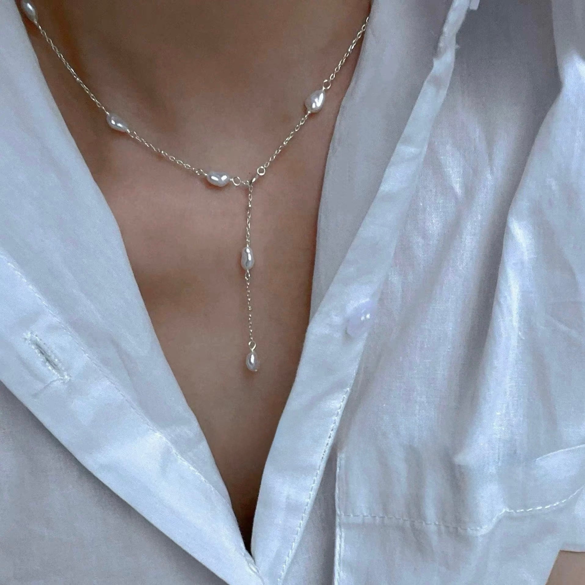 Small Keshi Pearl Necklace showcasing its wild freshwater pearls on a model wearing a white shirt.