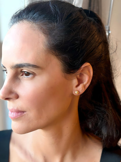Woman with dark hair wearing south sea golden pearl earrings, featuring Keshi pearls and 18K solid gold
